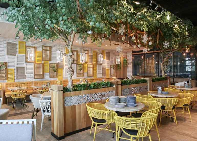 yellow chairs, greenery, wooden tables