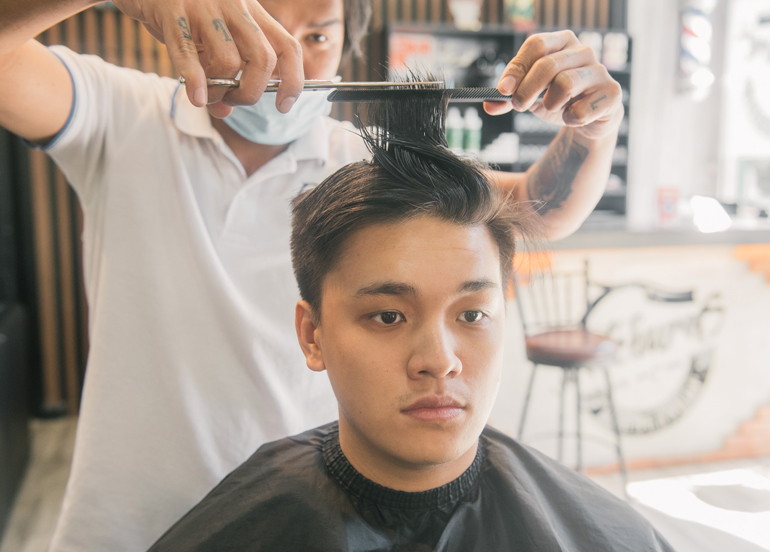 Sideburns Barbershop barber and client getting a haircut