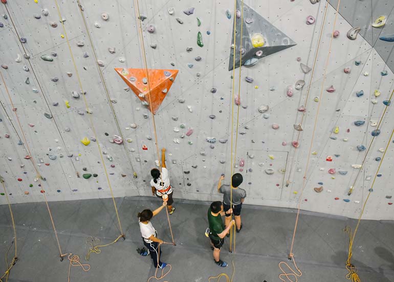 4 people wall climbing