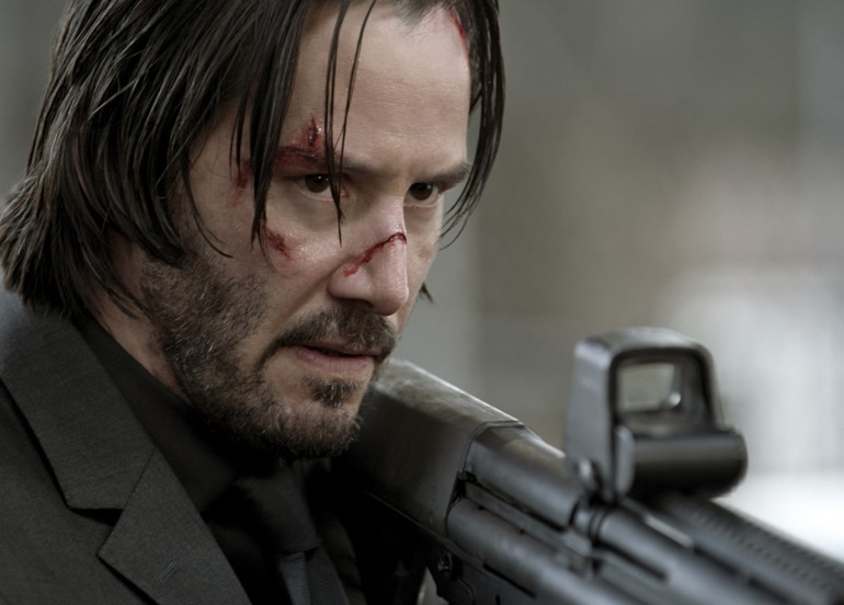 John Wick holds gun