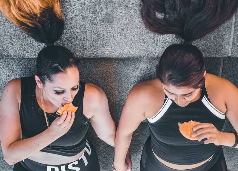 2 woman eating burger