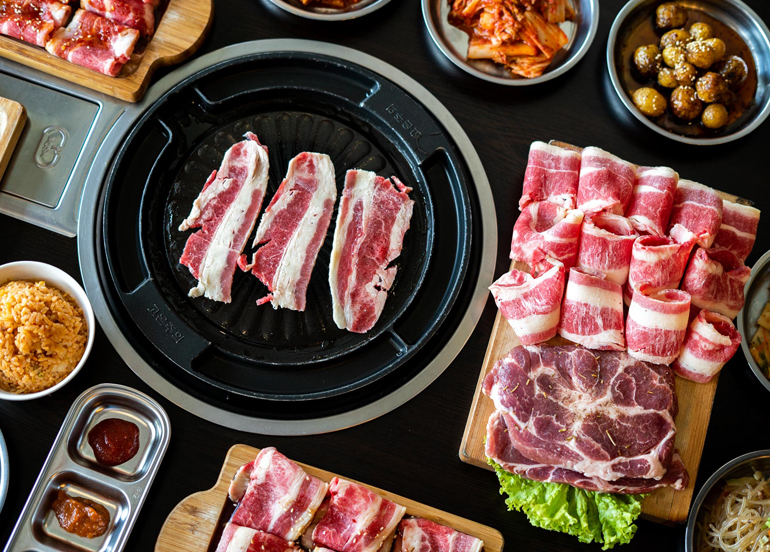 Flatlay of Raw Pork, Beef, and Korean side dishes on display