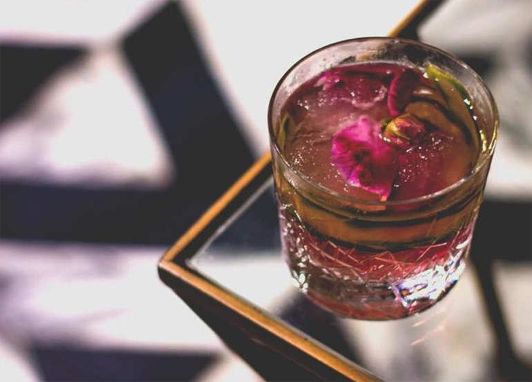 Bank Bar cocktail with gin, cucumber and petals as garnish