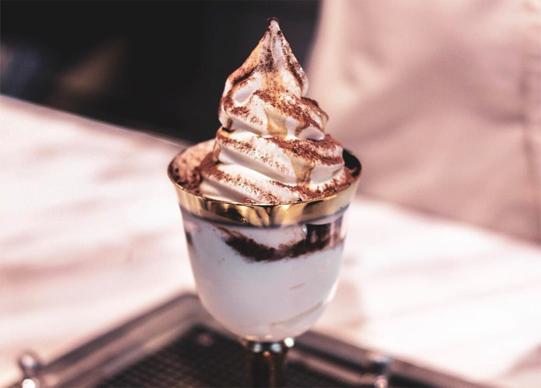 Tiramisu flavored ice cream topped with cocoa powder and served in a goblet