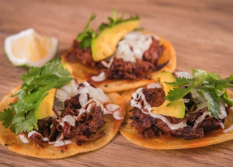 Extra Spicy Pulled Beef Taco from Drive-By Taco Shop topped with cilantro, onions, and avocado