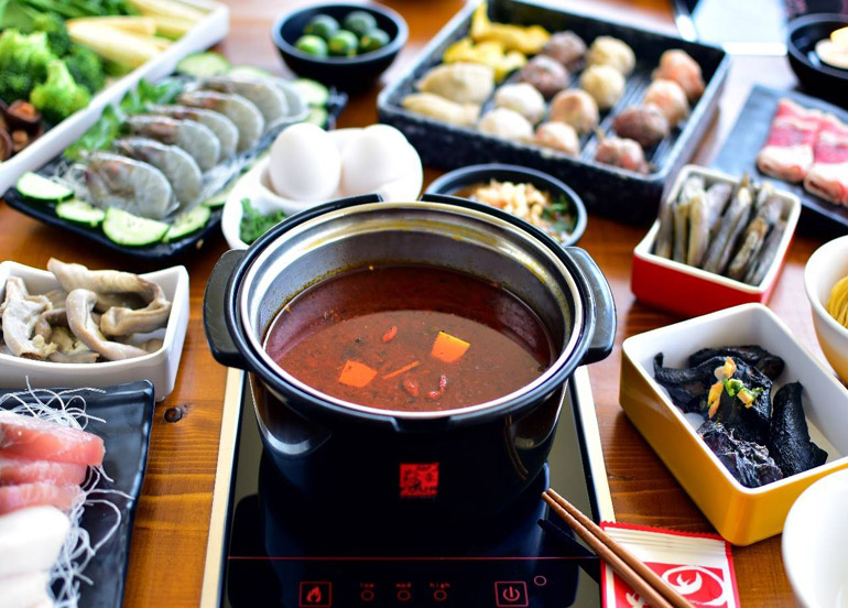 Hotpot in Spicy Broth accompanied by an assortment of seafood, fishballs, dumplings, meat, and vegetables