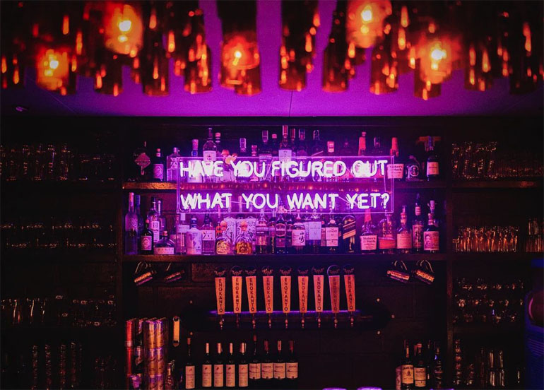 Polilya interior with neon-lit signs and an assortment of hard liquor