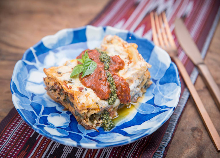 Cosmic's Vegan Lasagna topped with marinara sauce and pesto