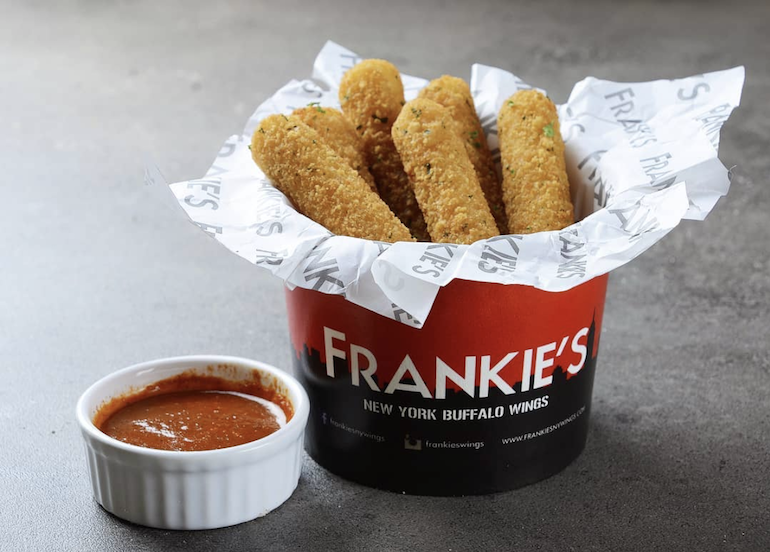 A bucket of Frankie's deep-fried mozzarella sticks with a side of sauce